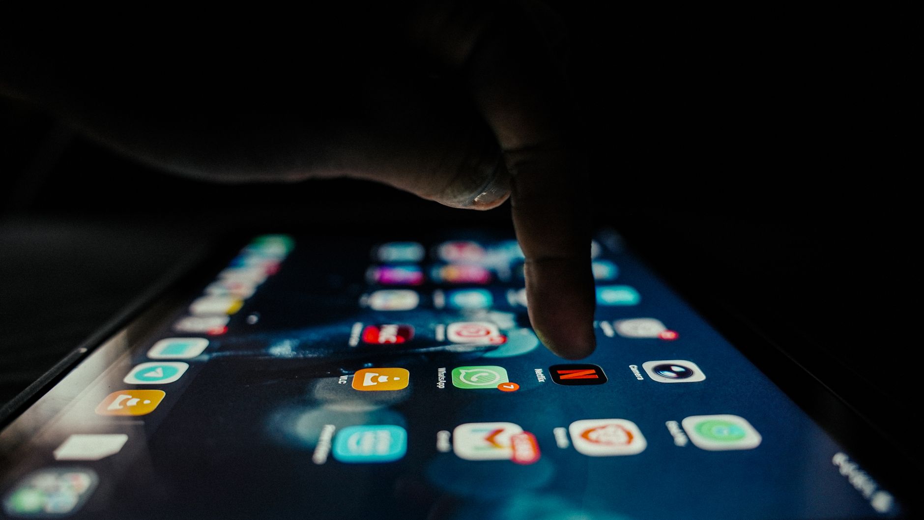 A hand on a phone in dim light, a page arriving