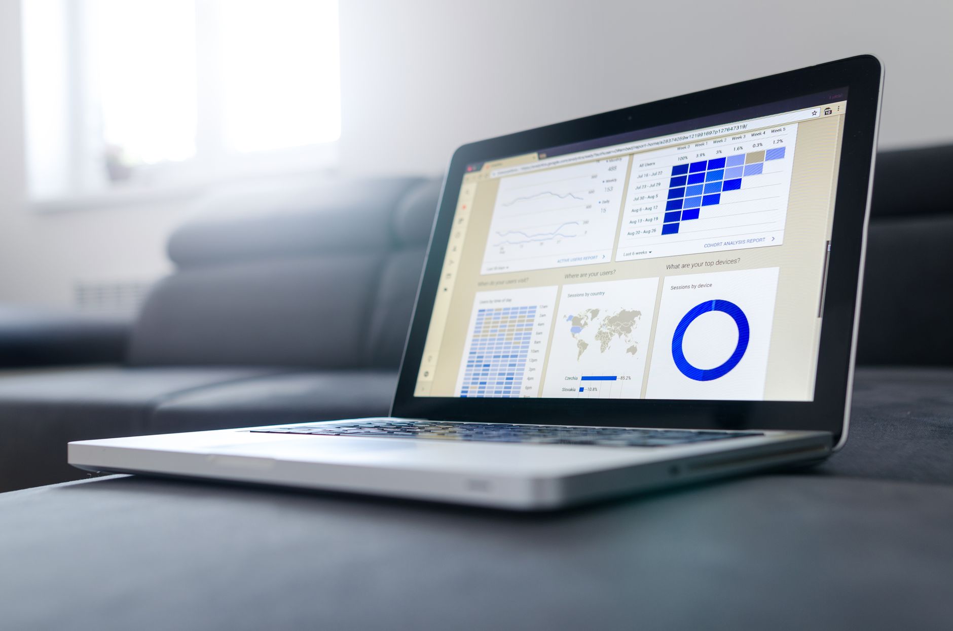 A laptop with data graphs in a bright room